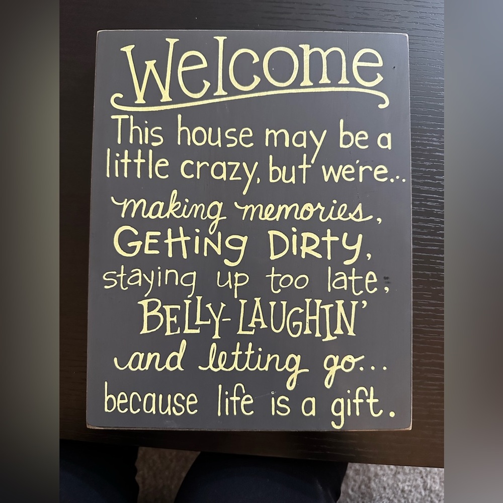 Welcome sign. Dark grey with gold writing